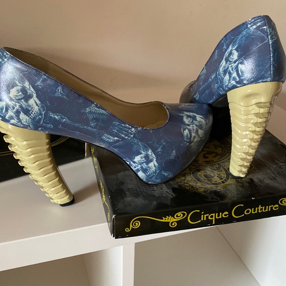 Too Fast bluish black chunky heel pumps with cream skulls.